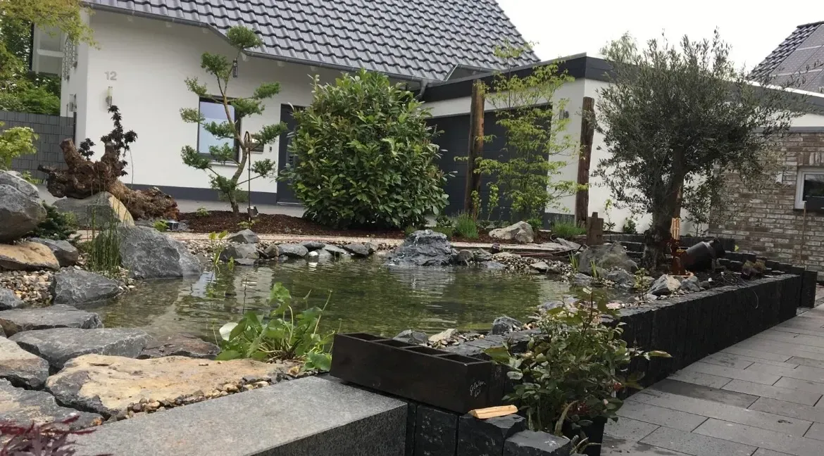 Ein Haus mit einem Teich davor.