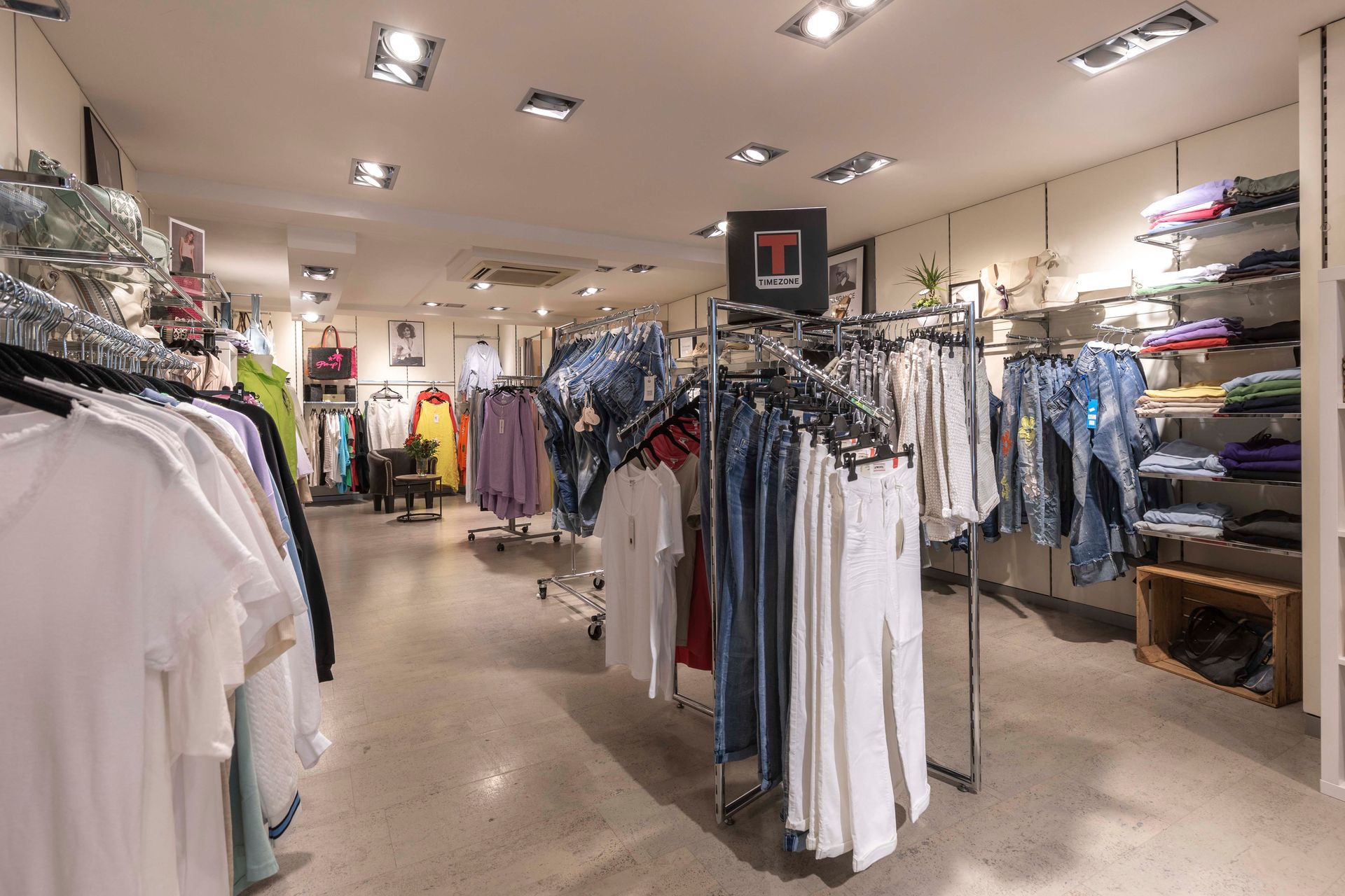 Ein Bekleidungsgeschäft mit vielen Kleidungsstücken, die an Kleiderständern hängen.
