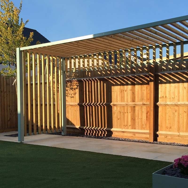 Une pergolas contre une cloison en bois.