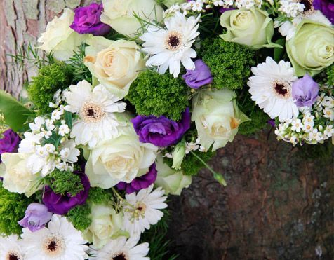 Un primer plano de una corona de flores blancas y moradas.