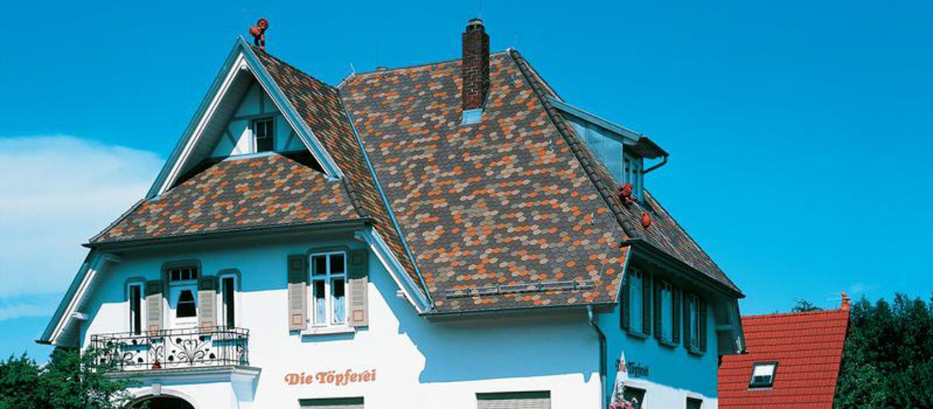 Detailliertes Dach mit farbigen Mustern – Arbeiten der Frank Sperling Dachdecker GmbH