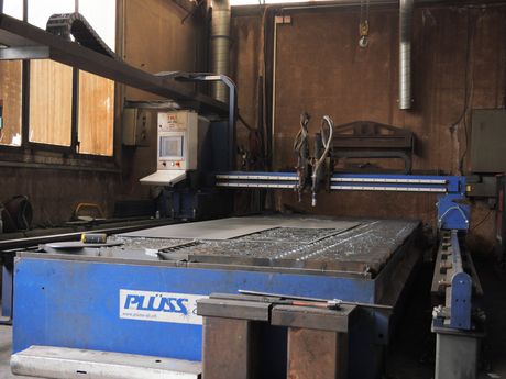 Découpe laser automatisée de tôles, créant des étincelles en usine.