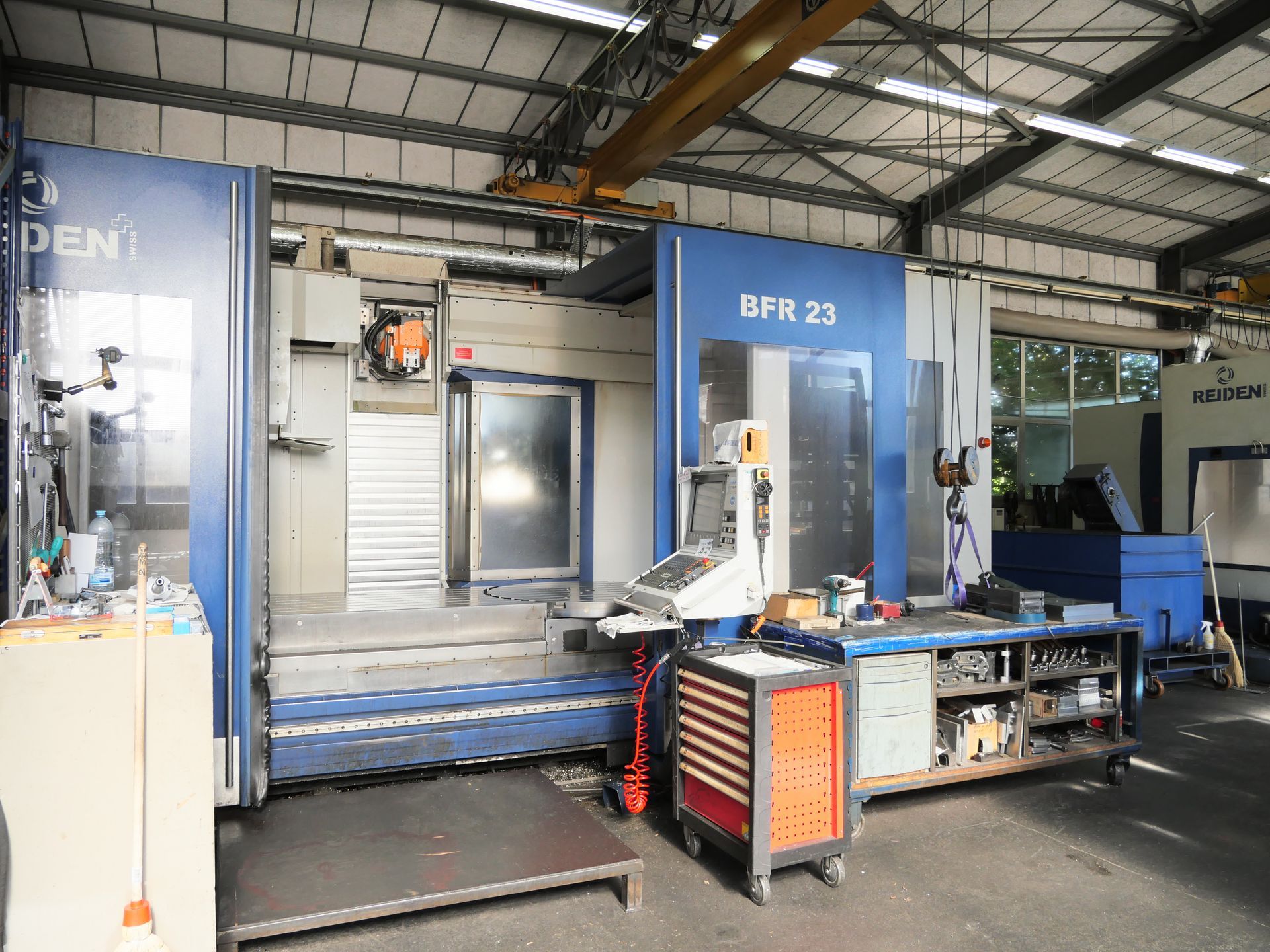 Fraiseuse CNC perçant un bloc de métal argenté avec des copeaux sur la surface de travail