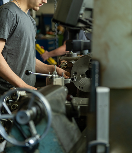Un ouvrier utilisant des machines dans un environnement de fabrication, pliant une pièce de métal.