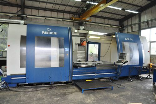 Une grande fraiseuse bleue Reiden SFR 16 à l'intérieur d'une usine.