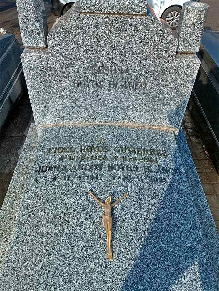 Lápida de Fidel Hoyos Gutiérrez y Juan Carlos Hoyos Blanco, con fechas de nacimiento y muerte; crucifijo de bronce.