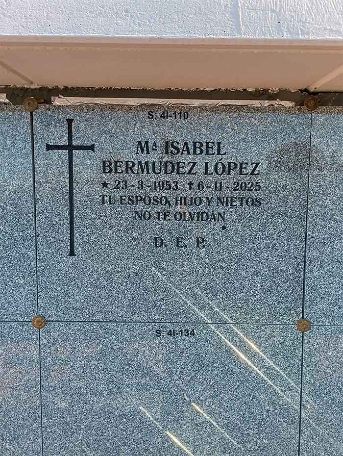 Lápida: María Isabel Bermúdez López, nacida en 1933, fallecida en 2025. Símbolo de cruz, fondo azul, texto en español.