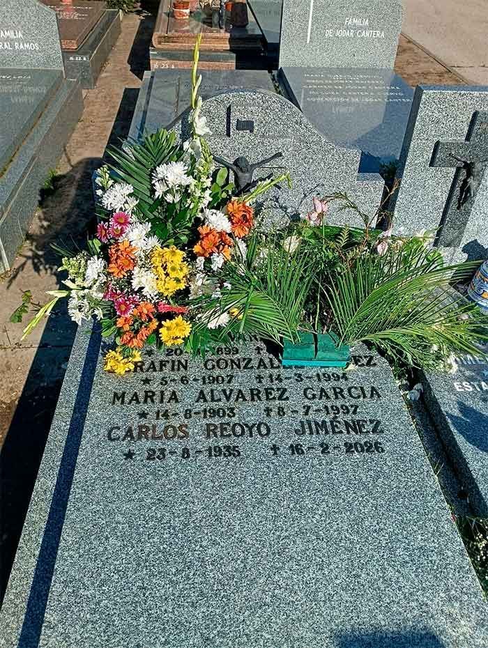 Tombstone with flowers. Names, dates inscribed: María Álvarez García, Carlos Reyo Jiménez. Colorful floral arrangement.