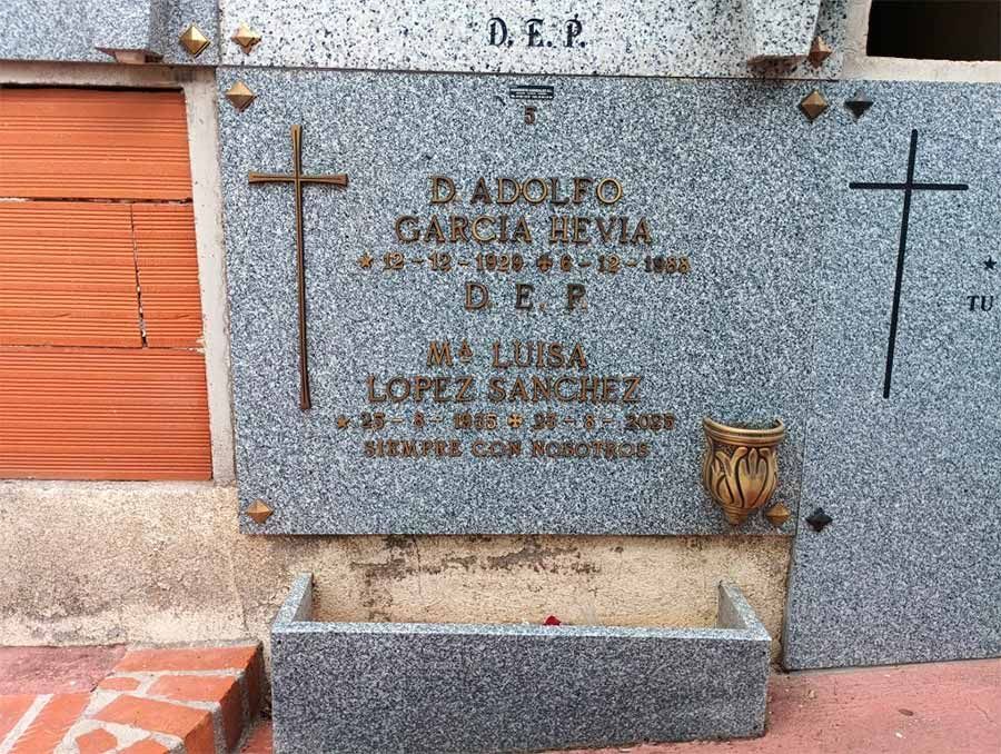 Lápida con nombres, fechas y detalles de cruces, en la que aparecen 