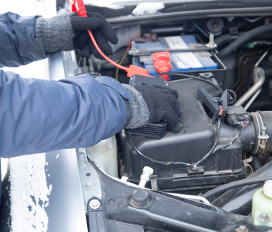 Une personne charge une batterie de voiture avec un démarreur