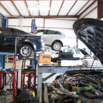 Une voiture est assise sur un ascenseur dans un garage avec le capot ouvert
