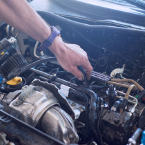 Une personne travaille sur le moteur d'une voiture.