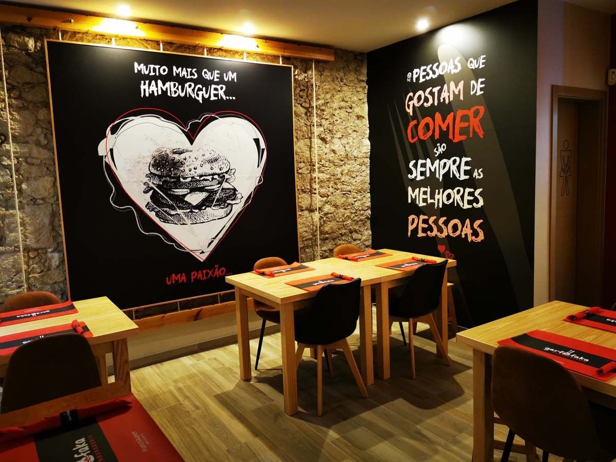 Um restaurante com mesas e cadeiras e um coração na parede