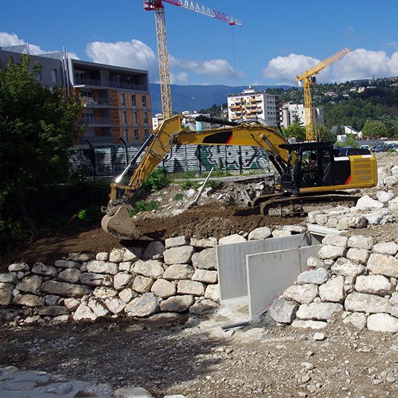 Mur de pierres et tractopelle
