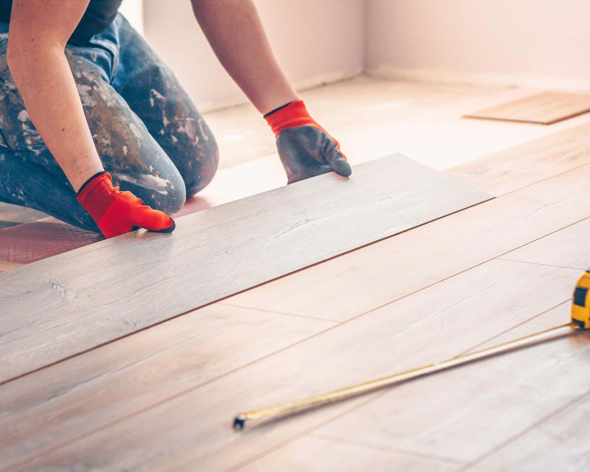 Ein Handwerker verlegt im Rahmen einer Brandschadensanierung neues Parkett.