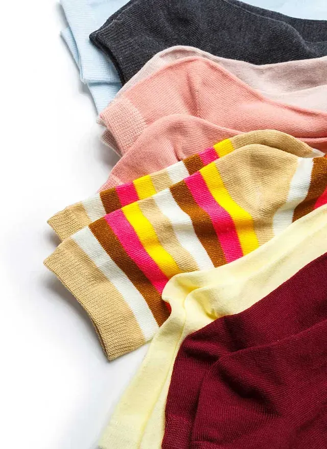 Un montón de calcetines de diferentes colores están apilados uno encima del otro.