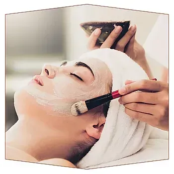 Una mujer está recibiendo un tratamiento facial en un spa.