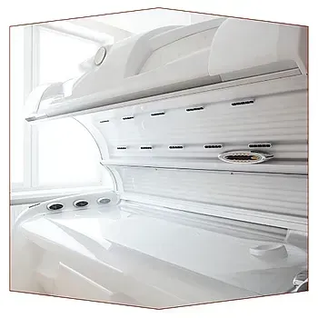 Una cama bronceadora blanca está situada frente a una ventana.