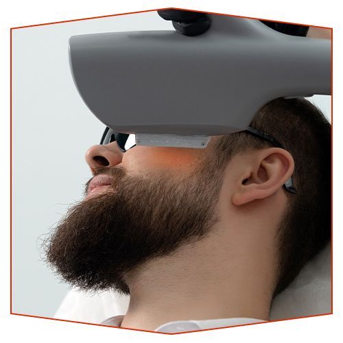 Las piernas de una mujer con uñas esmaltadas de negro descansan sobre una superficie blanca.