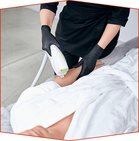 Un profesional que usa guantes negros utiliza un dispositivo de depilación láser en el antebrazo de un cliente en un spa.