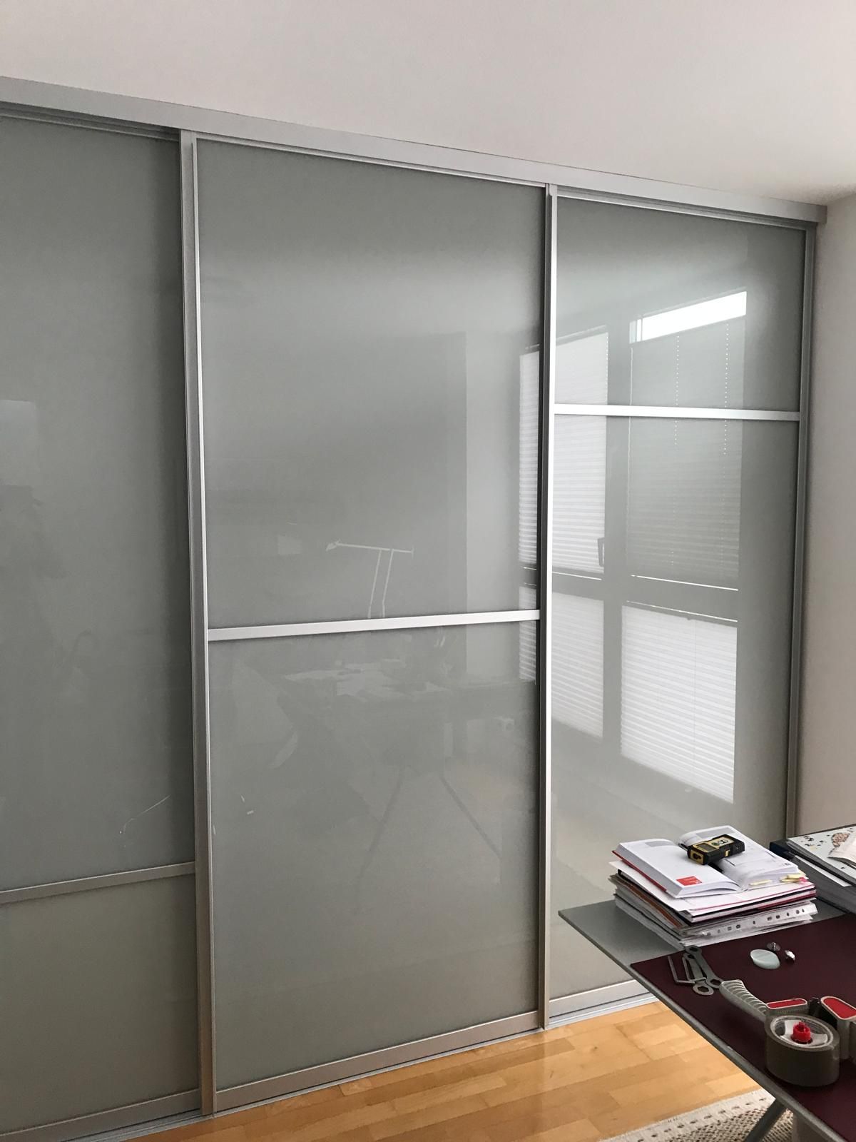 Ein Zimmer mit Glasschiebetüren und einem Schreibtisch.