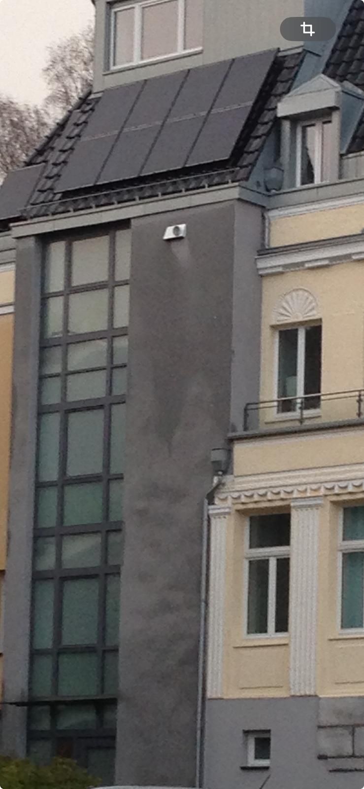 Ein Gebäude mit vielen Fenstern und Sonnenkollektoren auf dem Dach