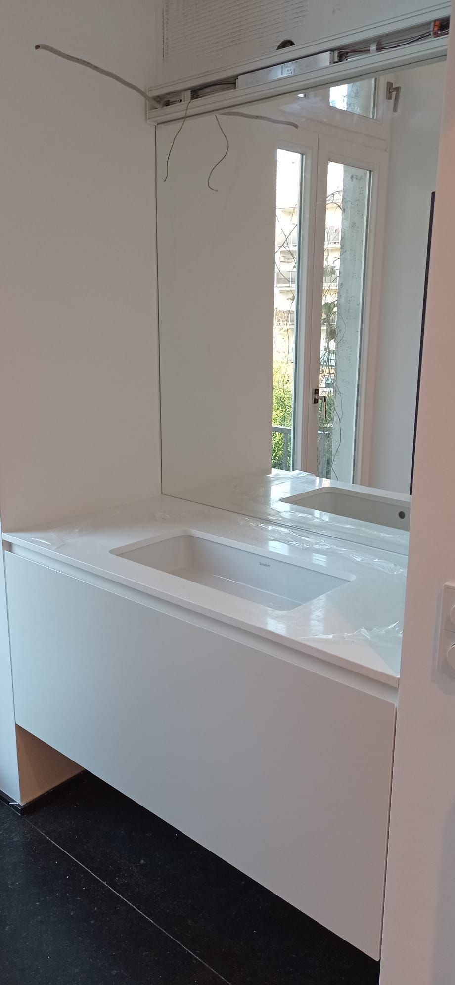 Ein Badezimmer mit Waschbecken und großem Spiegel.