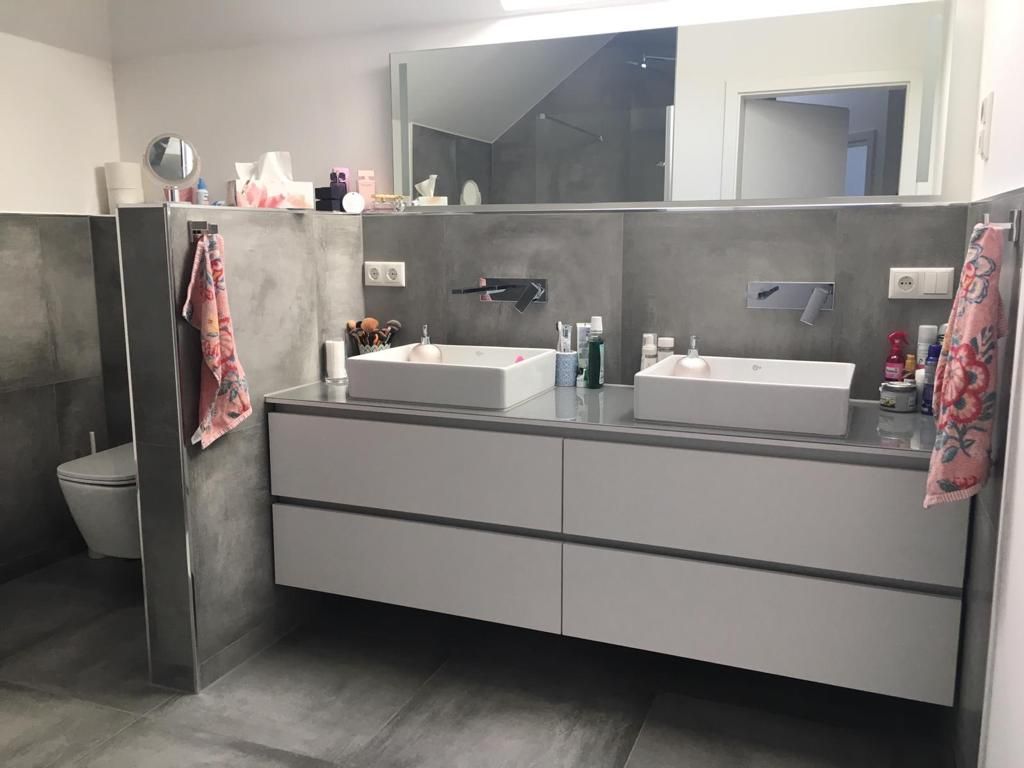 Ein Badezimmer mit zwei Waschbecken, einer Toilette und einem Spiegel.