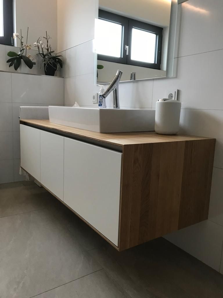 Ein Badezimmer mit Waschbecken und Spiegel an der Wand.