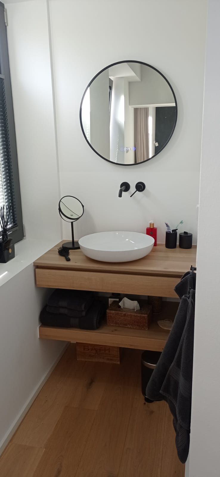 Ein Badezimmer mit Waschbecken, Spiegel und Fenster.