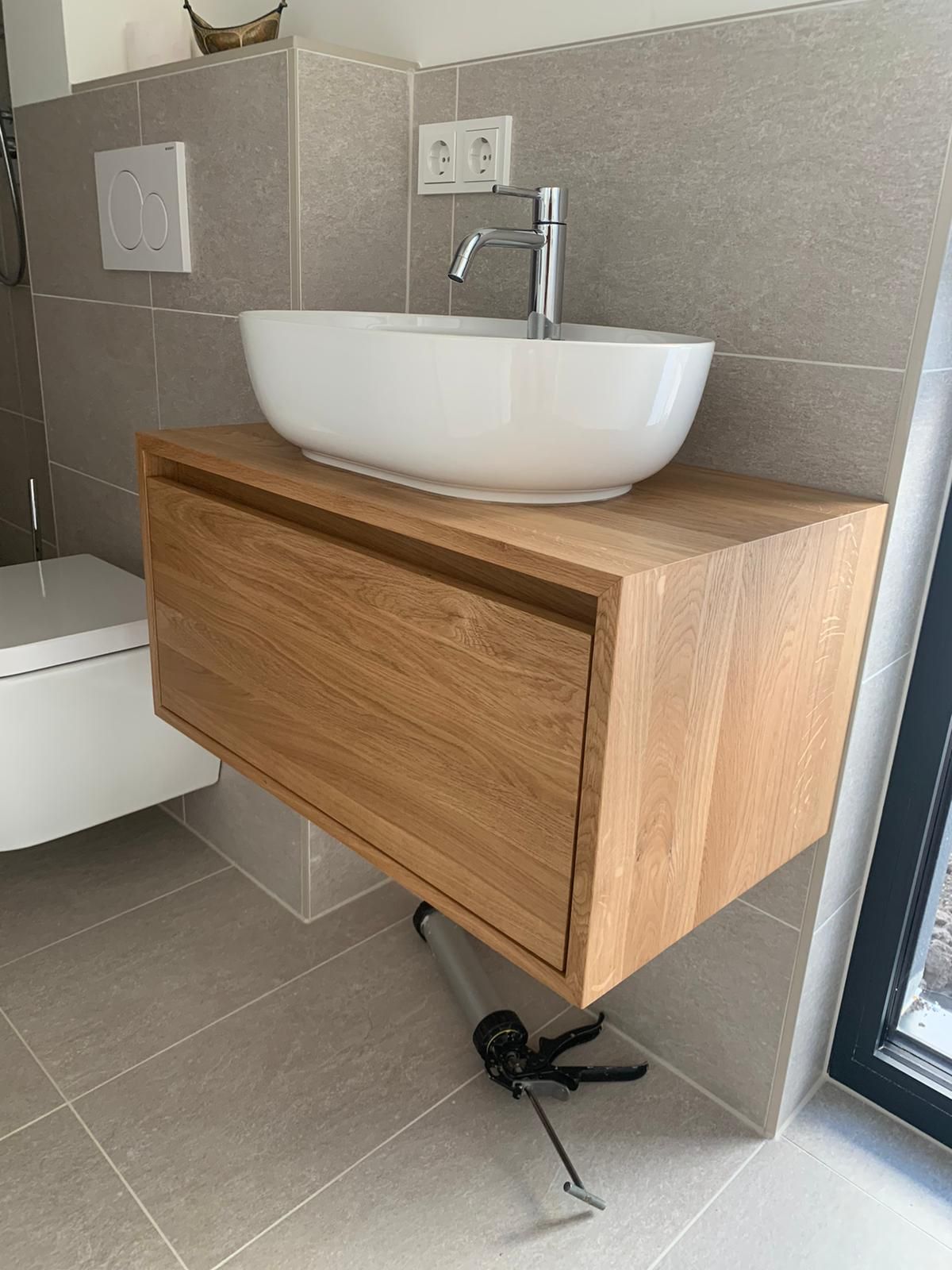 Ein Badezimmer mit Waschbecken, Toilette und Holzschrank.