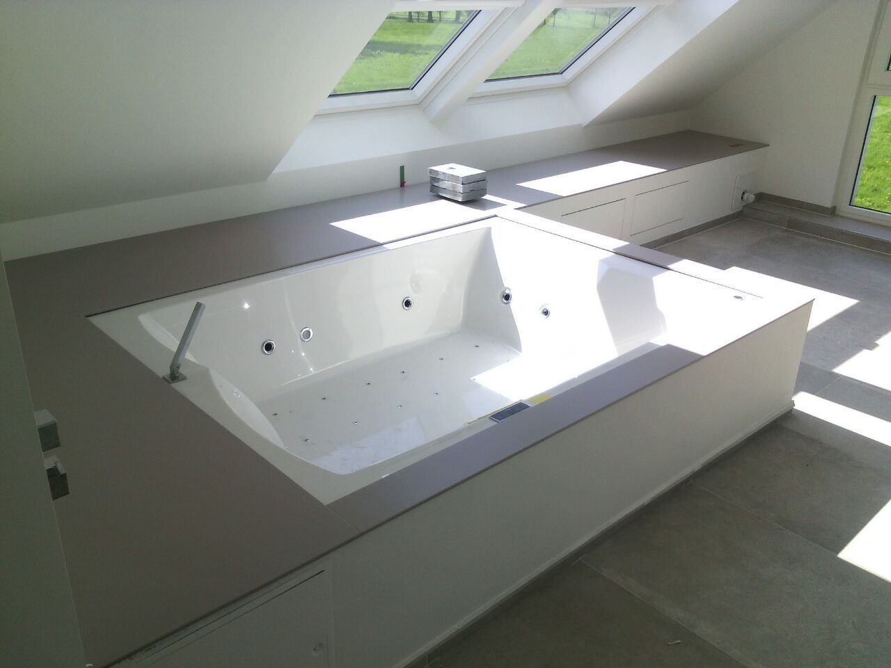 Eine Badewanne in einem Badezimmer mit einem Oberlicht darüber