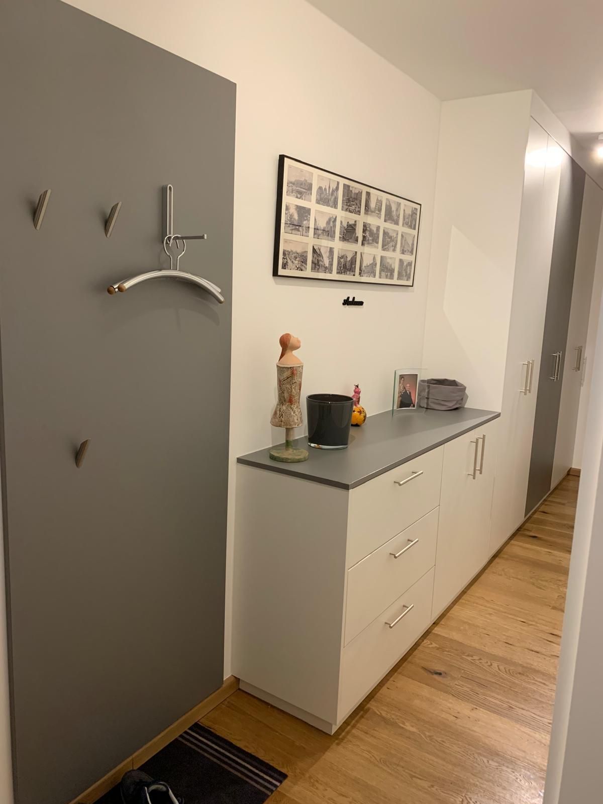 Ein Flur mit einer Kommode und einem Bild an der Wand.