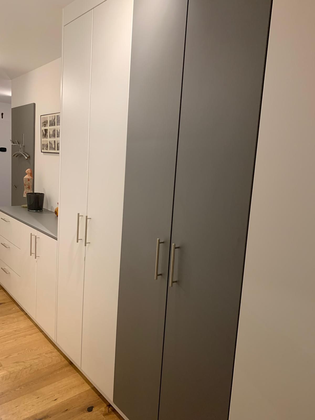 Ein Flur mit vielen Schränken und einem Holzboden.