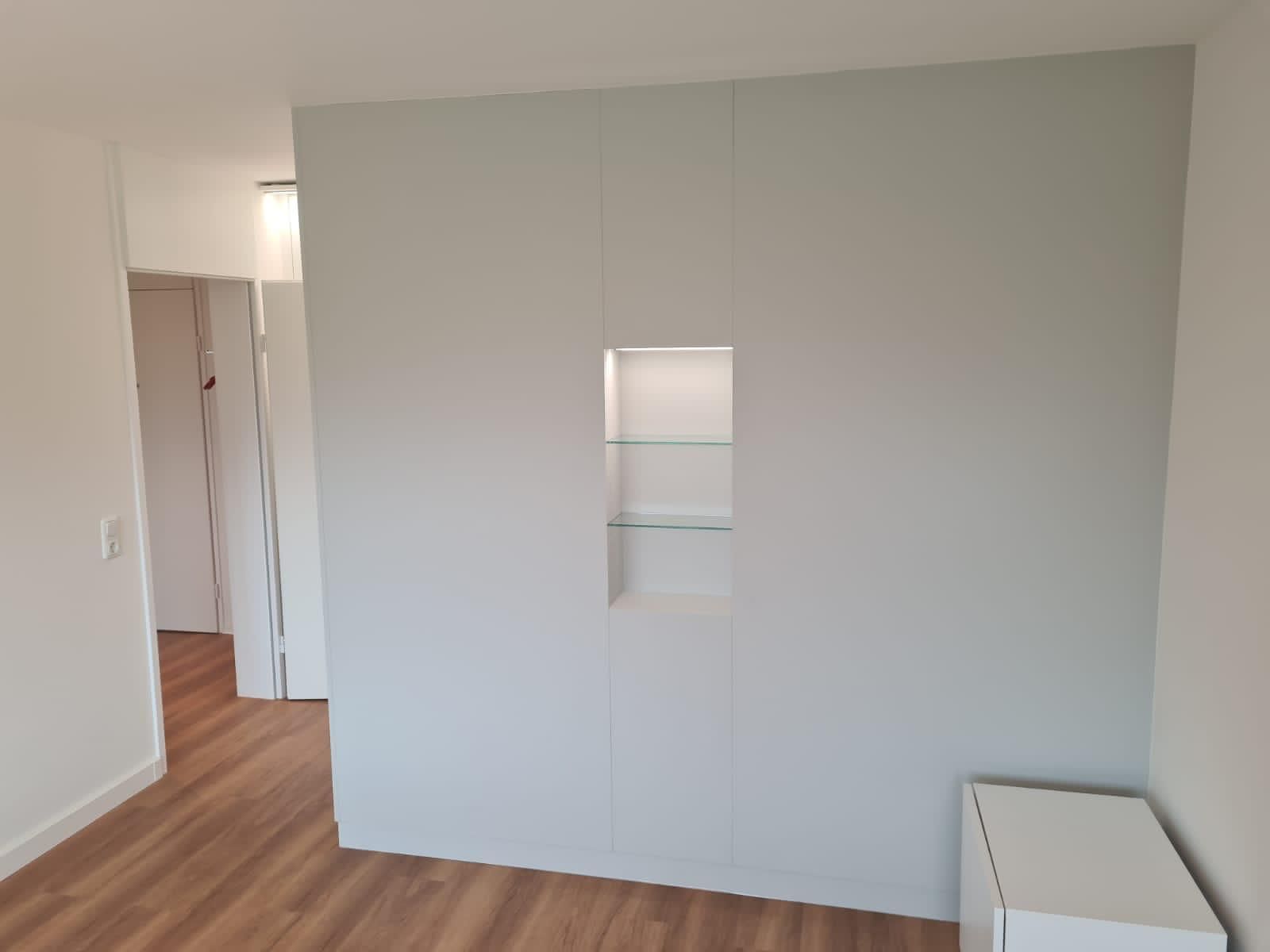 Ein Raum mit einer weißen Wand und Holzböden