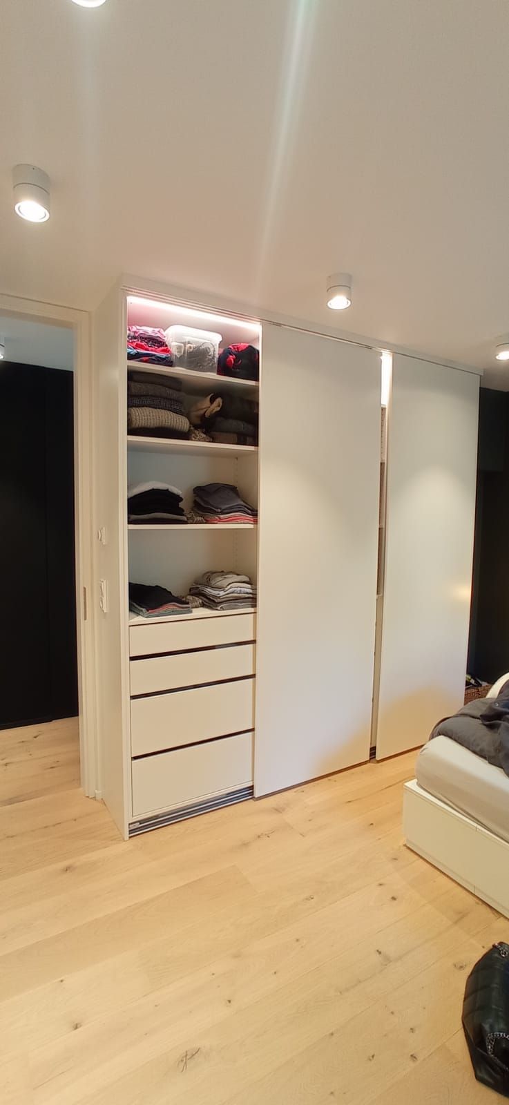 Ein Schlafzimmer mit begehbarem Kleiderschrank und Bett.