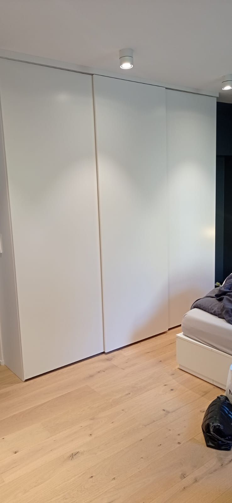 Ein Schlafzimmer mit einem Bett und einem großen weißen Kleiderschrank.