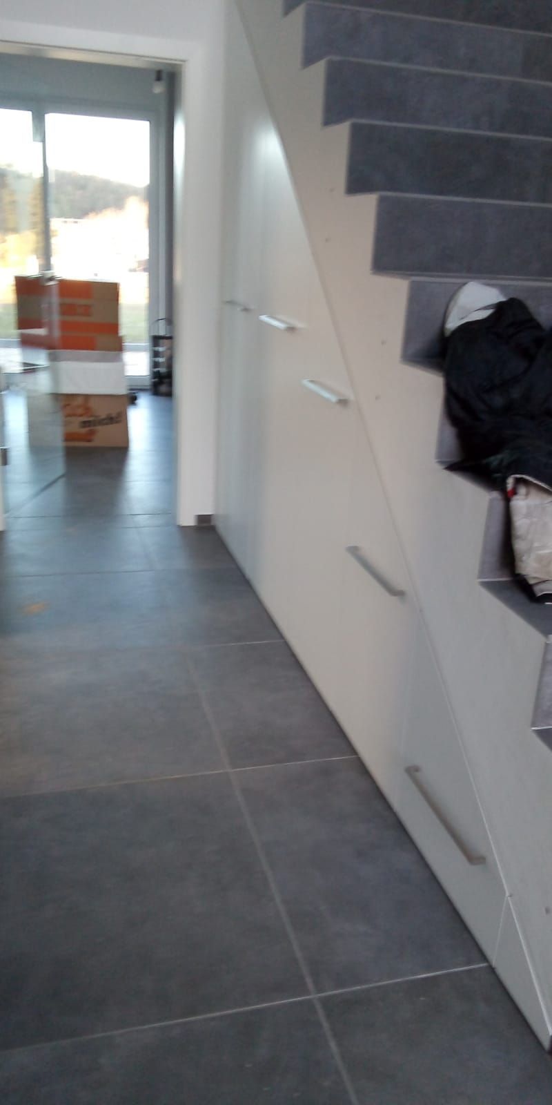 Ein Flur mit einer Treppe, die in den zweiten Stock eines Hauses führt.