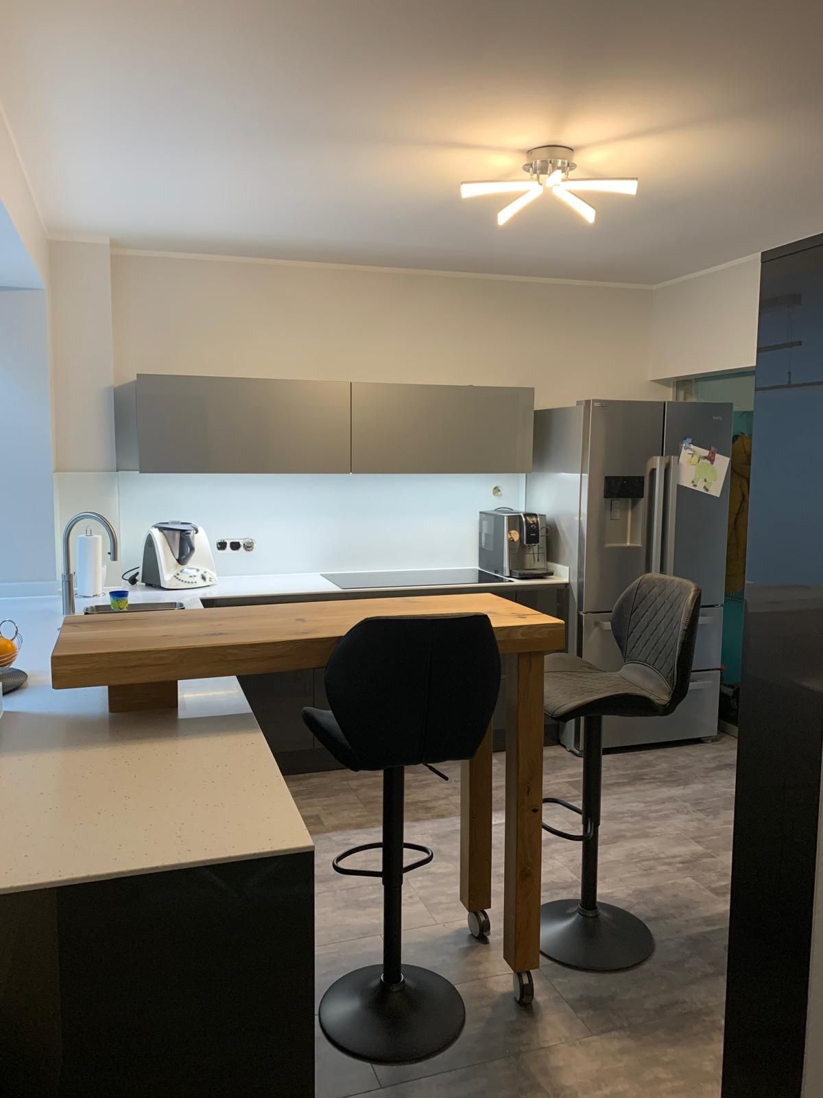 Eine Küche mit Holztisch und Stühlen und einem Kühlschrank.