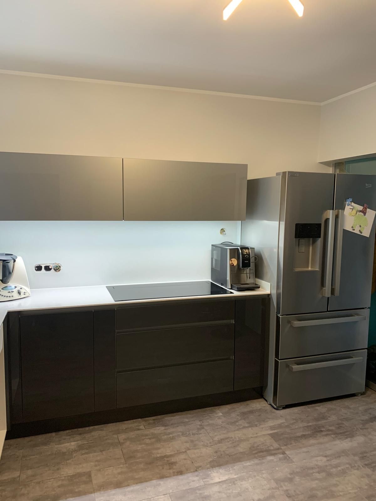 Eine Küche mit Kühlschrank, Herd, Spüle und Mikrowelle.