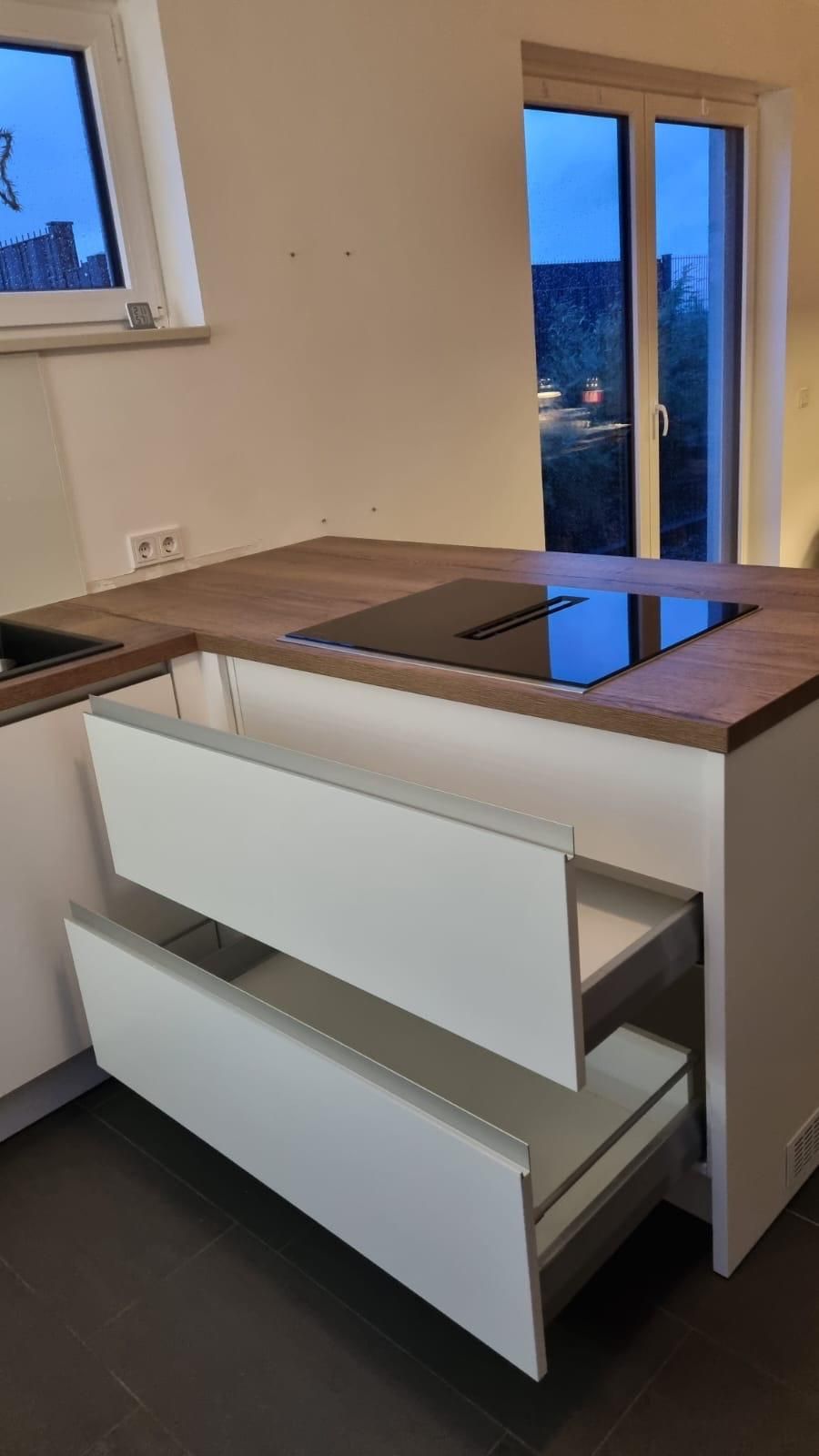 Eine Küche mit zwei offenen Schubladen und einem Herd mit Backofen.