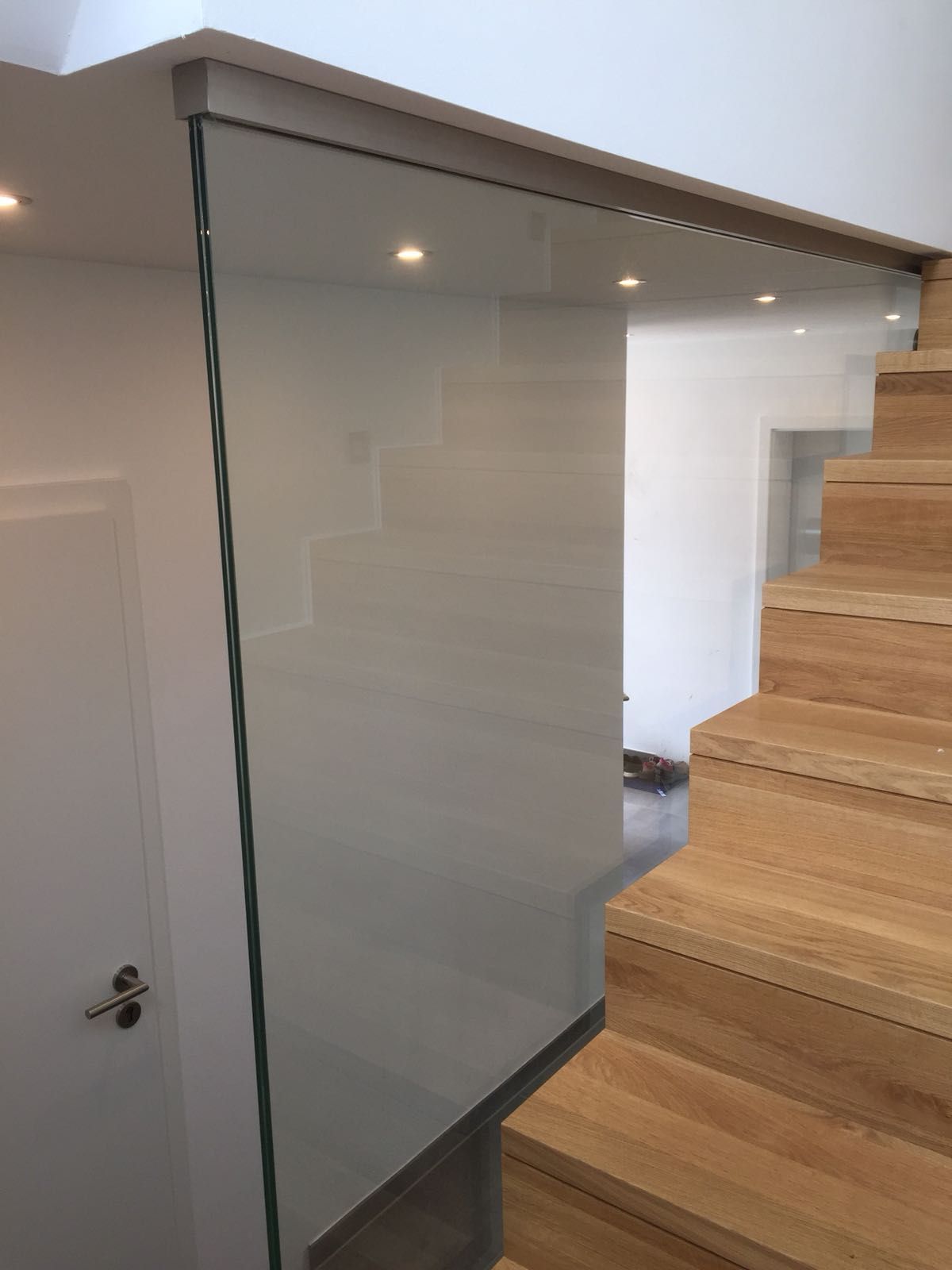 Eine Treppe mit Holzstufen und einem Glasgeländer