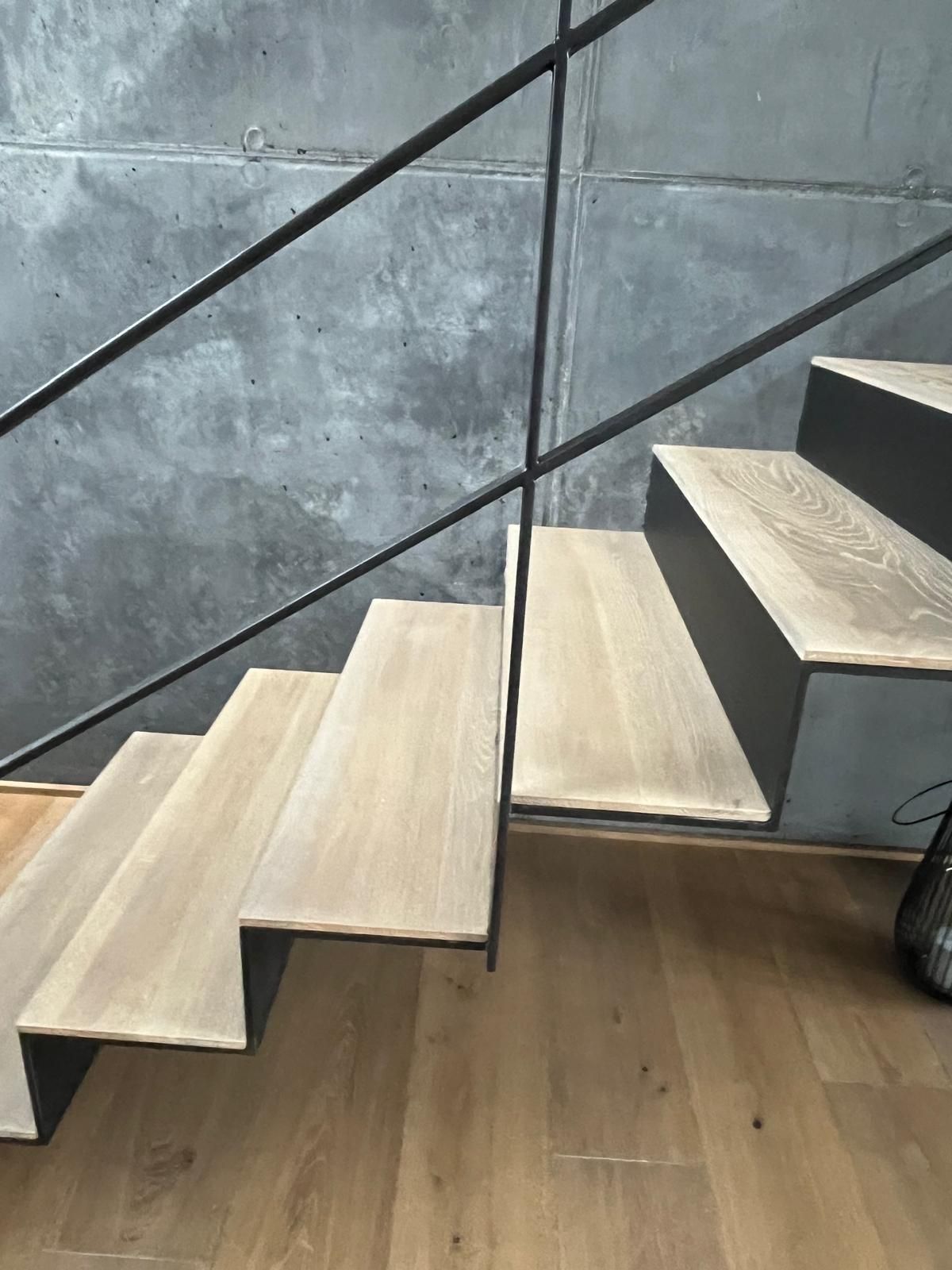 Eine Holztreppe mit Metallgeländer und Holzstufen.