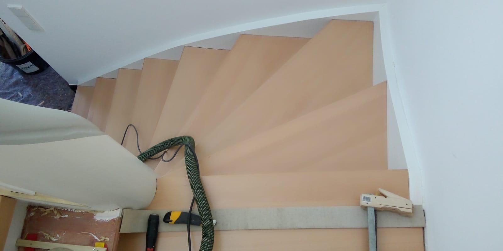 Auf einer Holztreppe steht ein Staubsauger.