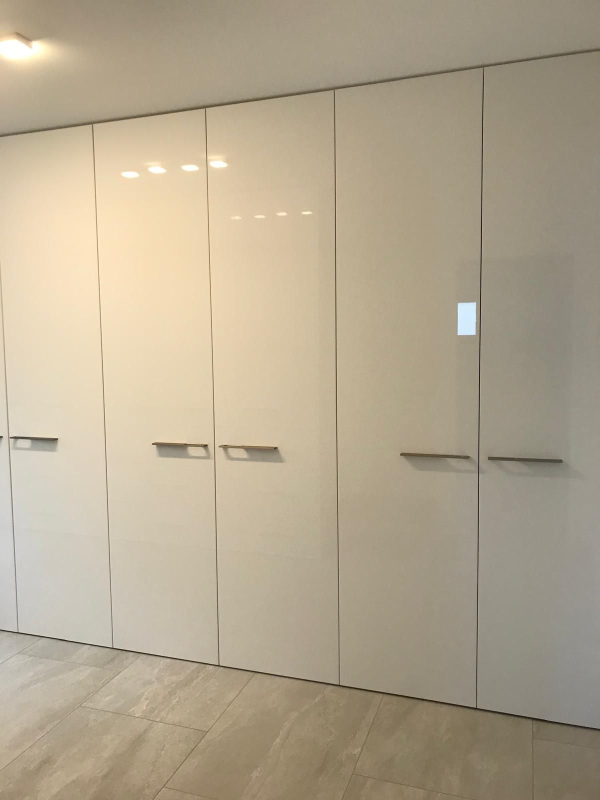 Ein Raum mit vielen weißen Schränken an der Wand