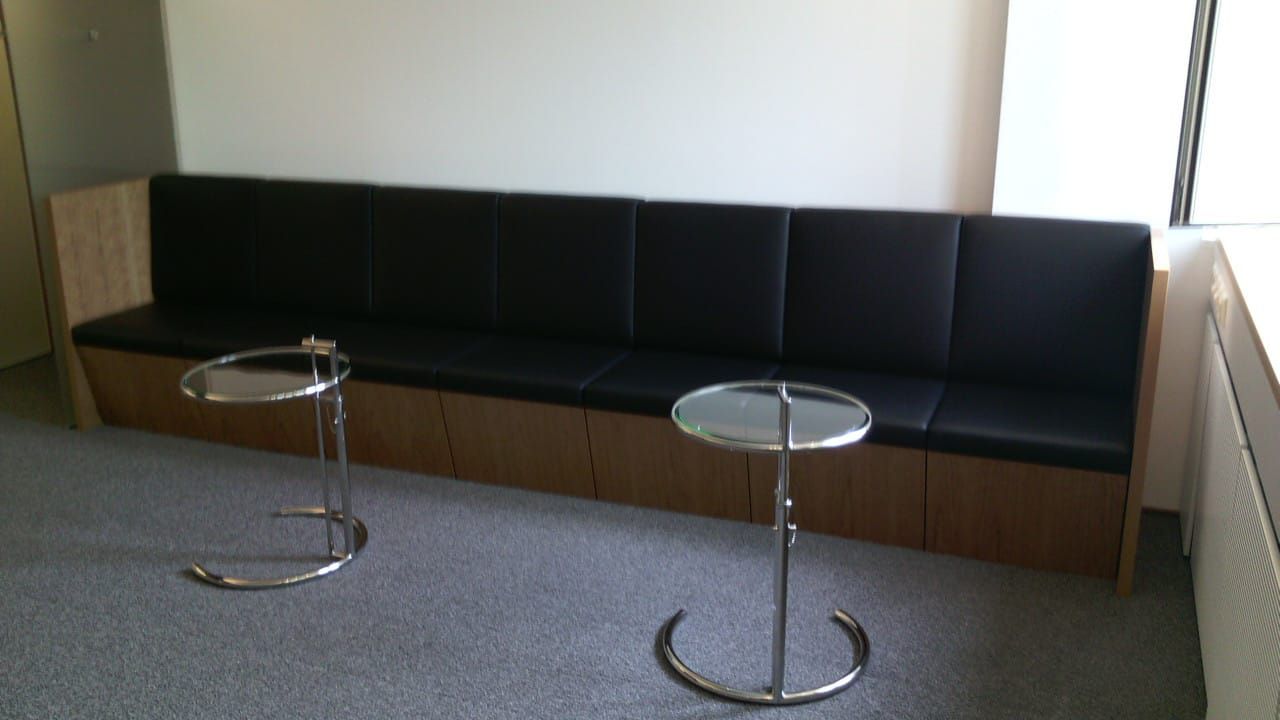 Ein Wartezimmer mit einer Couch und zwei Tischen