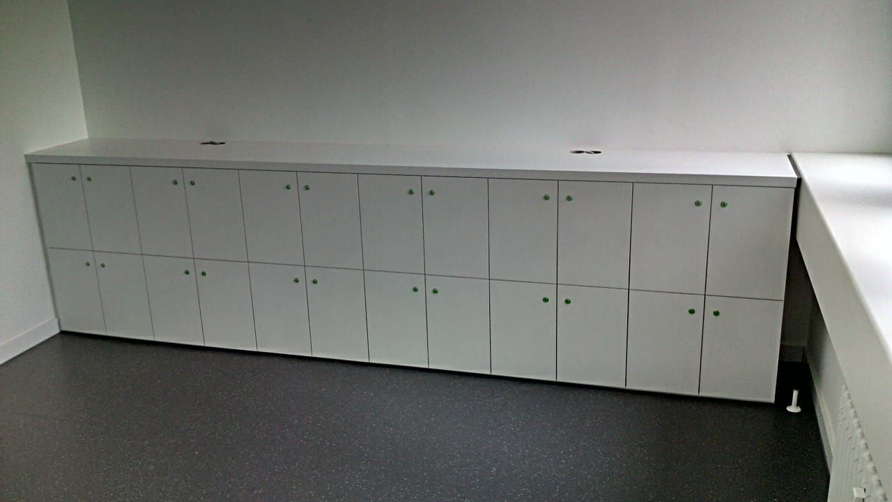 Ein Raum mit vielen weißen Schränken an der Wand