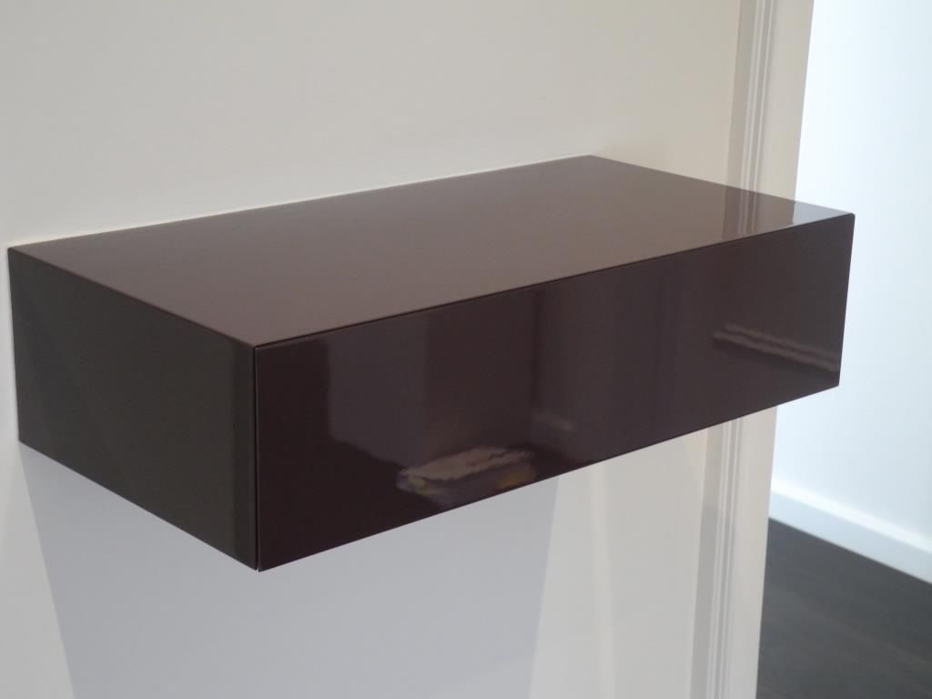 Ein schwarzes Regal hängt an einer Wand neben einer Tür
