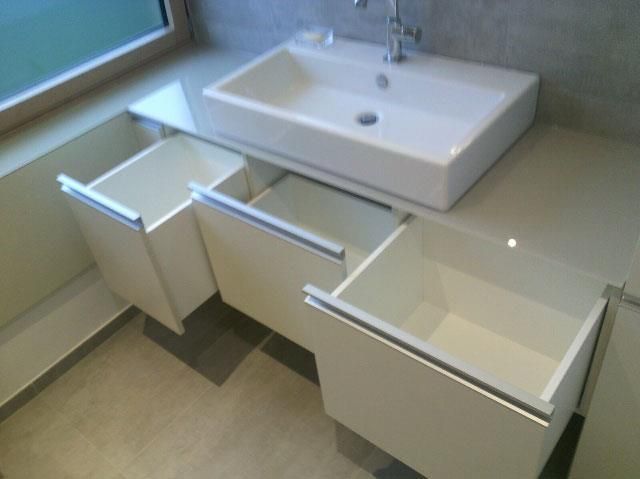 Ein Badezimmer mit Waschbecken und offenen Schubladen
