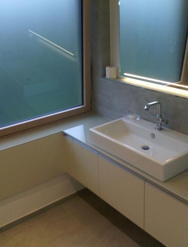 Ein Badezimmer mit Waschbecken, Spiegel und Fenster